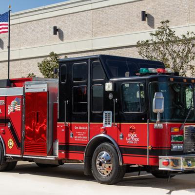 Hook and Ladder Pizza Co food truck parked outside a building with an American flag.
