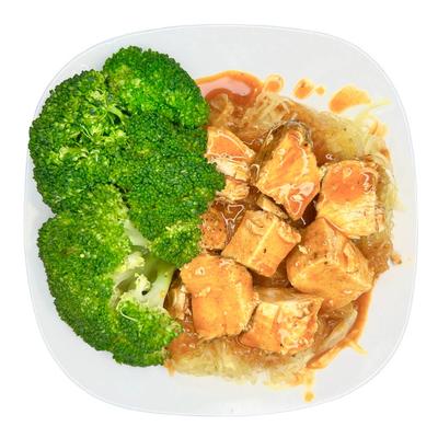 Steamed broccoli with saucy chicken pieces served on a white plate.