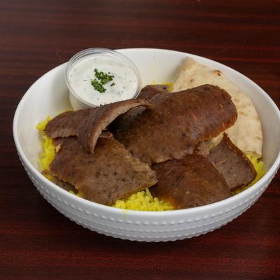Traditional Gyro served in a bowl with rice, pita, and tzatziki sauce.