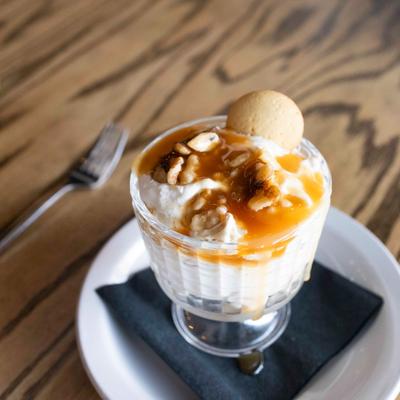 Banana pudding topped with caramel and nuts.