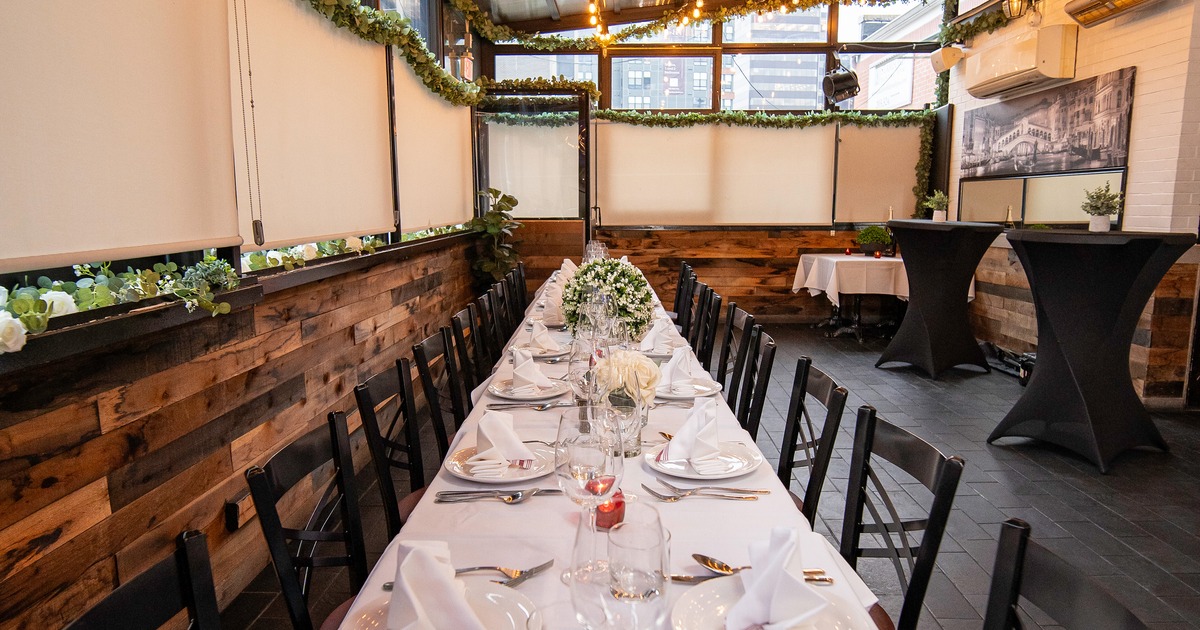 An elegant dining setup in an enclosed patio space set up for an upscale dinner gathering