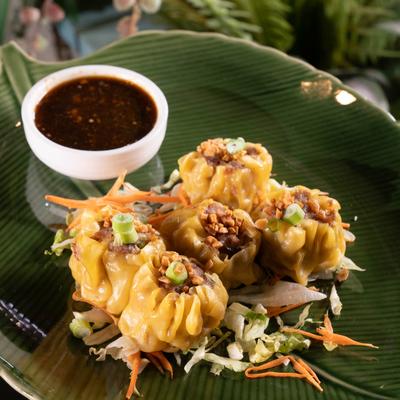 Steamed dumplings served with a sauce.