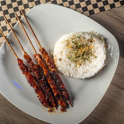 Pork belly and chicken skewers with rice on the side, top view.