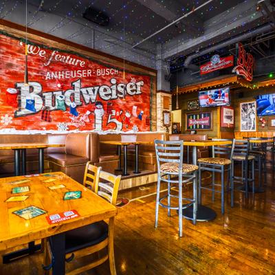 Interior with booths, tables, chairs and beer branding on the walls.
