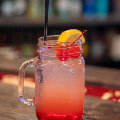 Red Shed Special cocktail, garnished with lemon and cherries.
