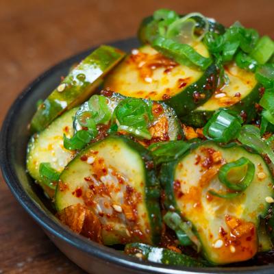 Spicy pickled cucumbers topped with scallions and chili crunch.