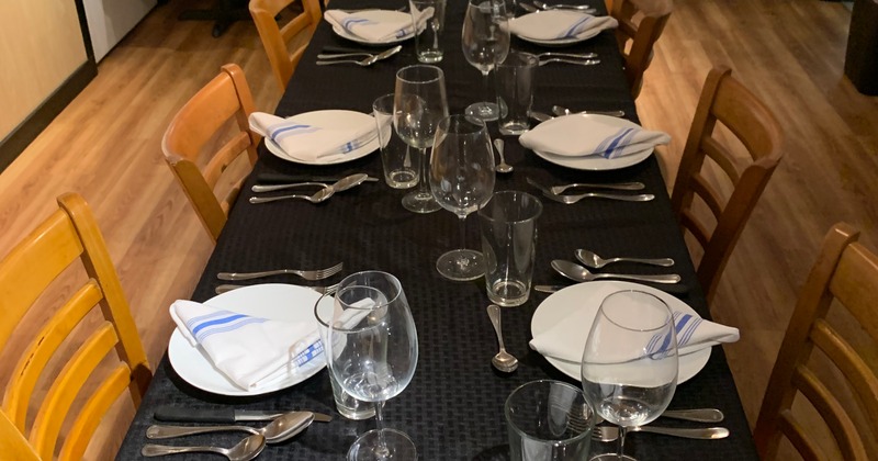 Interior, a long table with place settings, and glasses