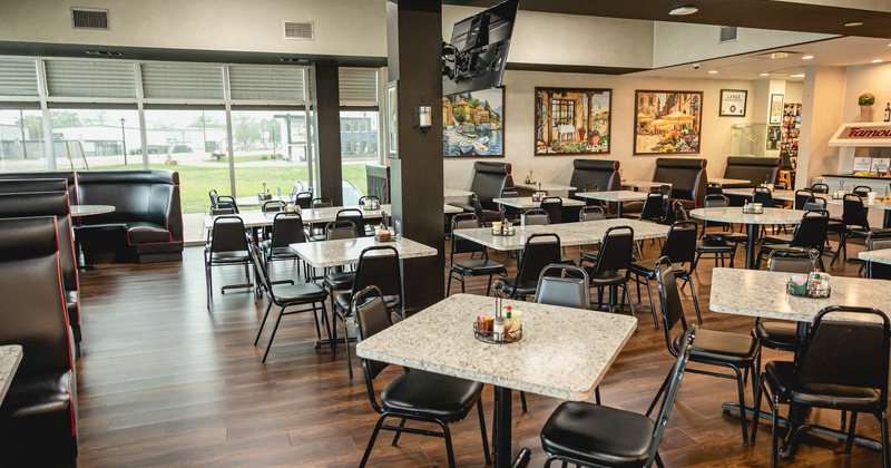 Interior, tables with chairs, images and TV on the wall
