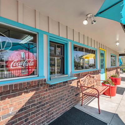 Retro style exterior with red brick walls, blue trim, and Coca-Cola sign on the window.