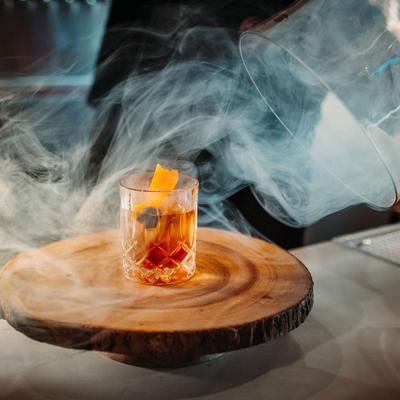 Smoked Old Fashioned served on a natural log board.
