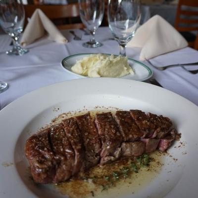 Sliced steak served with mashed potatoes on a table.