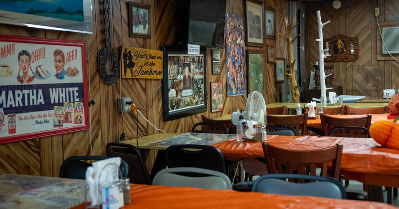 Interior of a diner with wood paneled walls decorated with vintage signs