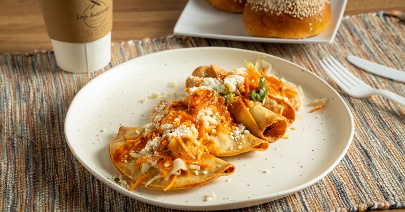 Tacos filled with mashed potatoes, topped with crumbled cheese and sauce