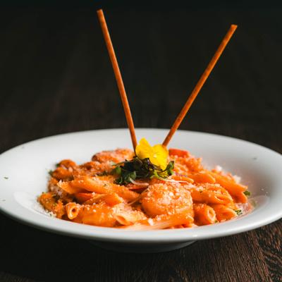 Penne Alla Vodka featuring shrimp, parmesan cheese and breadsticks.