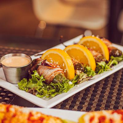 Jalapenos stuffed with queso and wrapped in bacon