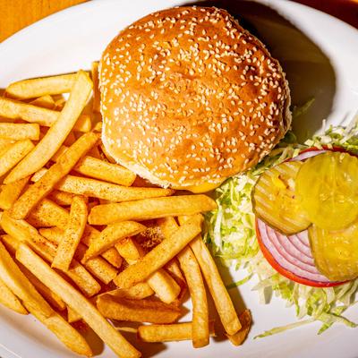 Bacon cheeseburger with lettuce, tomato, onion, pickles, and fries.