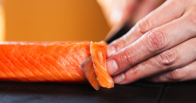 Salmon meat being cut, close up