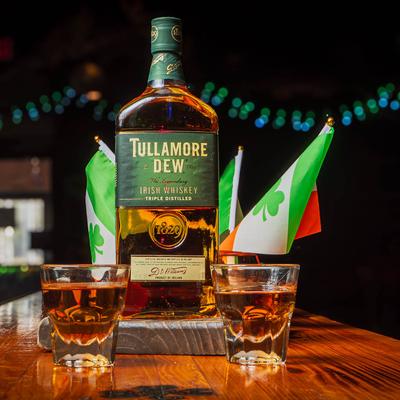A bottle and shots of Tullamore Dew whiskey.