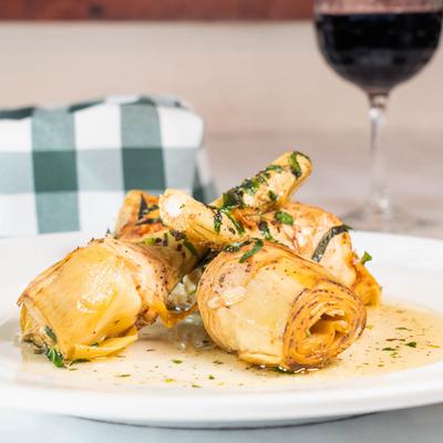 Sauteed artichokes served with a glass of red wine.