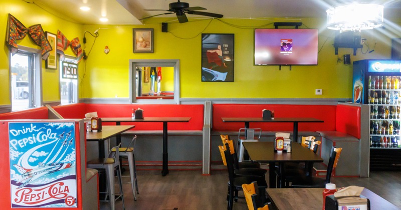 Interior of a restaurant with lime green walls, red booths