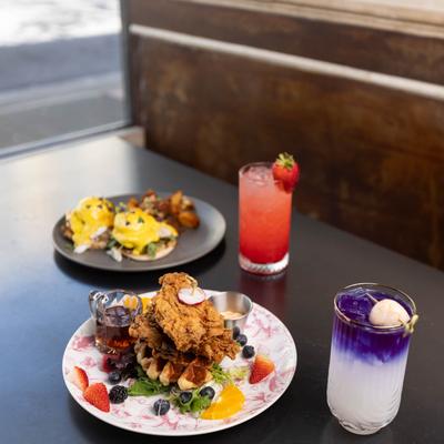 Chicken and croffle, Eggs Benedict plate, with Butterfly Lychee and a strawberry cocktail.