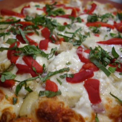 White pizza, with red peppers, and cilantro.