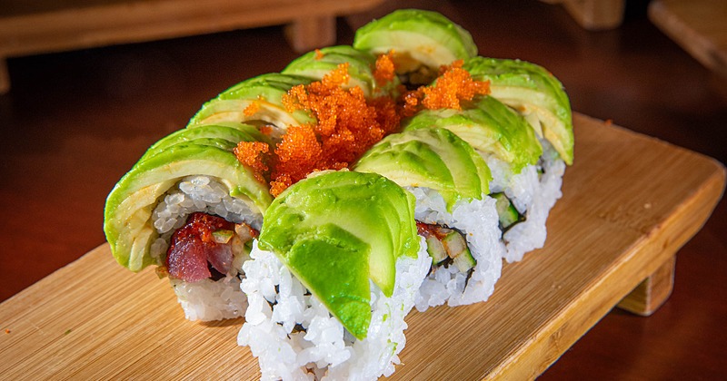 Tuna sushi rolls topped with avocado and roe