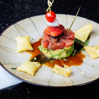 Tuna tartar with avocado, wonton chips and various garnishes.