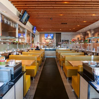 Restaurant seating with yellow booths and conveyor bar.