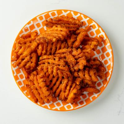 Sweet potato waffle fries on a patterned plate.