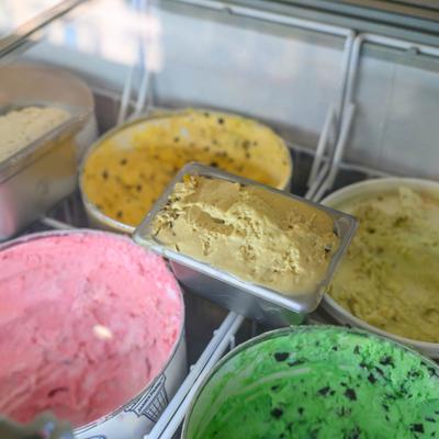 Assorted ice cream flavors stored in a freezer case.