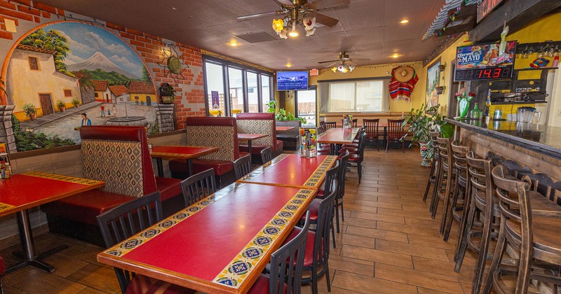 Interior space, dining tables and dining booths near the bar