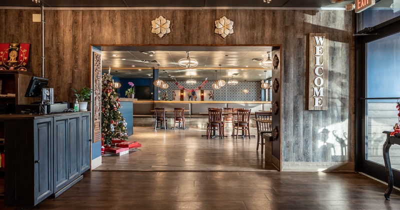 Entrance door and welcome sign on wall in checkout counter area with Christmas decoration