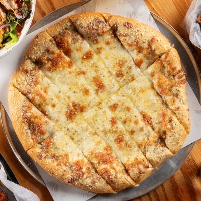 Cheesy Bread served on a metallic tray lined with paper, overhead view.