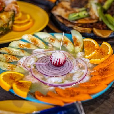 Aguachiles and other dishes on a table.
