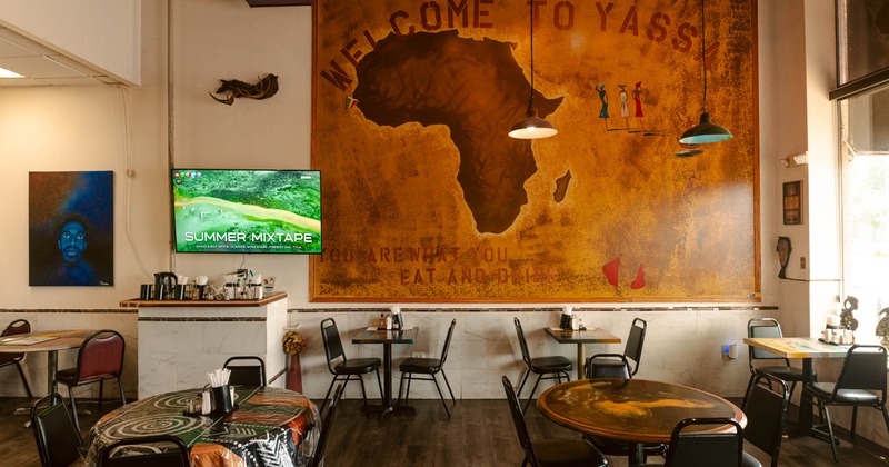 Interior seating area with a large mural of Africa, chairs and tables