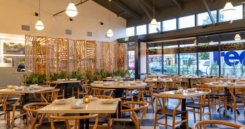 A modern interior with wooden furniture, decorative partitions and large windows