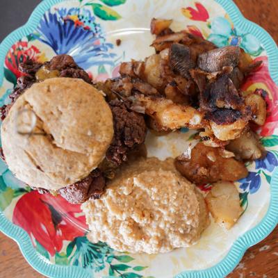 Sweet Heat Fried Chicken Biscuit with side of grits and smash browns.