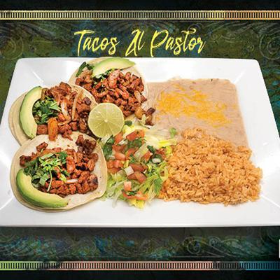 Tacos Al Pastor served woth sides of rice, salad and beans.