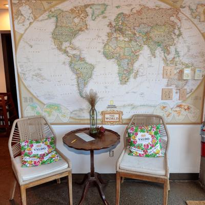 Two chairs next to round table, with world map on the back wall