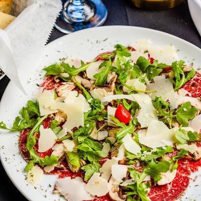 Thinly sliced beef carpaccio topped with arugula, mushrooms, shaved parmesan, and cherry pepper.