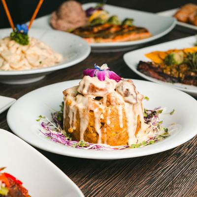 Mofongo de Chicharon served on the table alongside other dishes in the background.