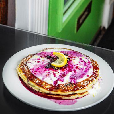 Pancakes with vanilla yogurt, blueberry compote, and lemon zest.