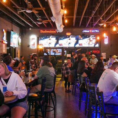Guests enjoying themselves in a busy bar.