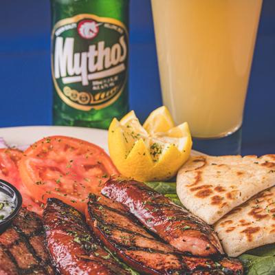 Loukaniko dish served with a greek beer