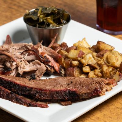 Brisket served with pulled pork, potatoes and collard greens.
