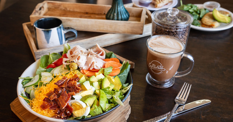 Chopped mixed salad, served on a table with a glass of coffee drink