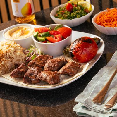 Grilled beef platter, with hummus, salad, and rice.