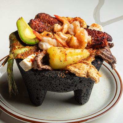 Molcajete filled with steak, chicken, shrimp, cheese and chorizo.