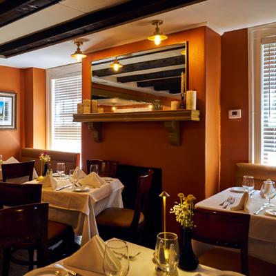 An elegant restaurant interior featuring tables set with white tablecloths.